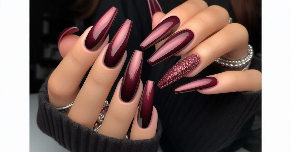 A stunning set of long coffin nails in a deep burgundy color, featuring a glossy finish.