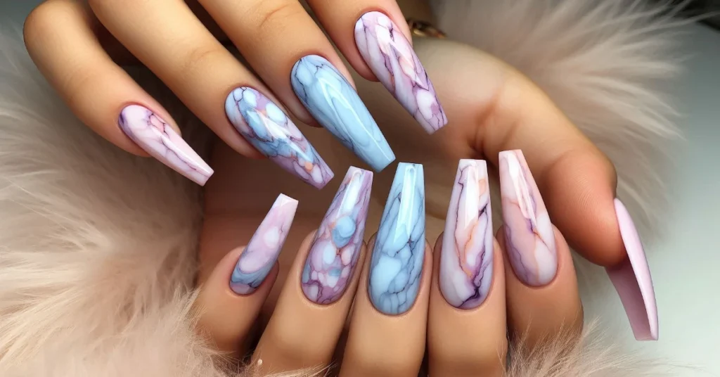 A swirl marble design on long coffin nails with soft pastel colors like lavender, baby blue, and light pink.