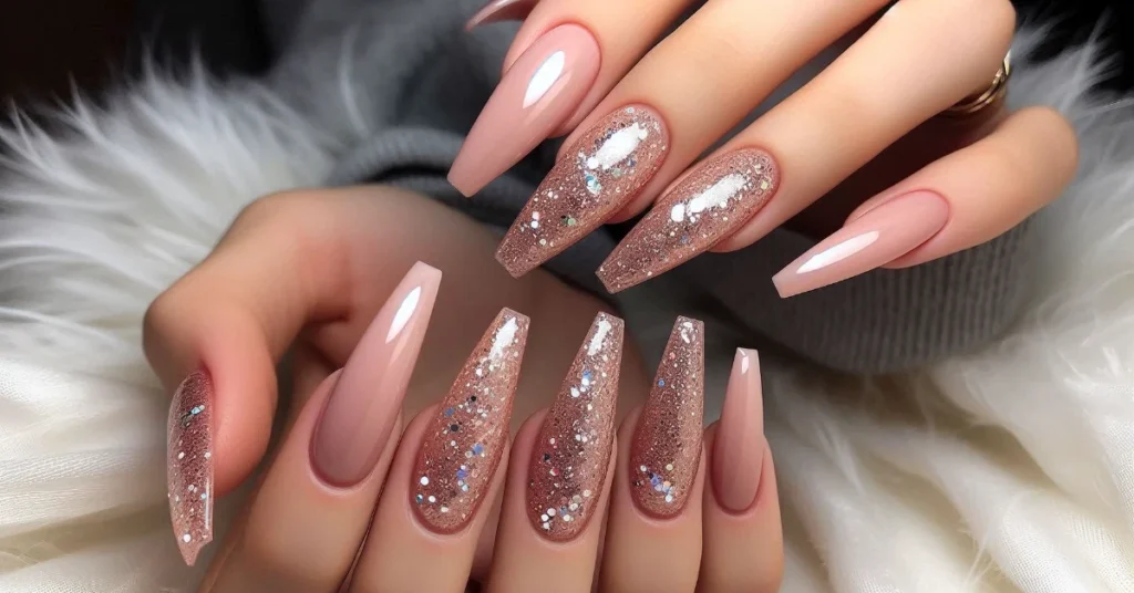 Long coffin nails with glitter accents on a nude base, creating a sparkling effect.
